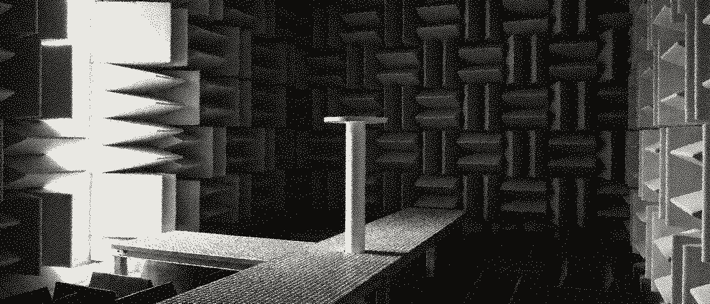 An empty test chamber lined with pale grey foam wedges, a bare white mast at the end of a steel grating walkway.