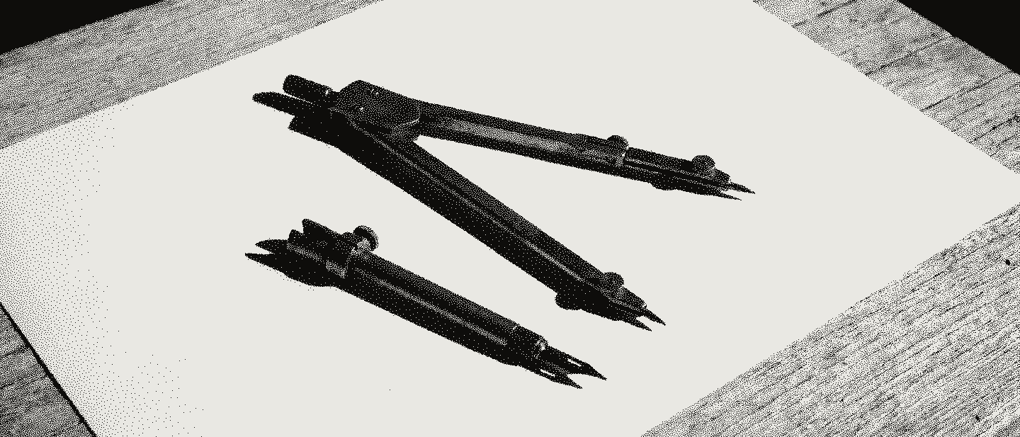 A brass drafting compass lying open on blank paper, one interchangeable leg removed and lying beside it.