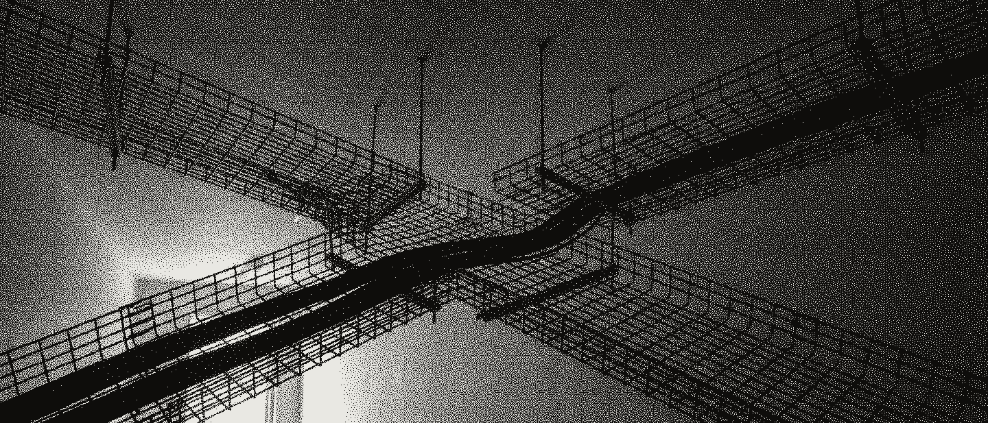 Two wire-mesh cable trays crossing under a pale ceiling, one carrying a cable bundle, a lit doorway beyond.